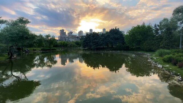 Lake park view and behind modern buildings silhouette at sunset in Istanbul, Turkey. (4K video)