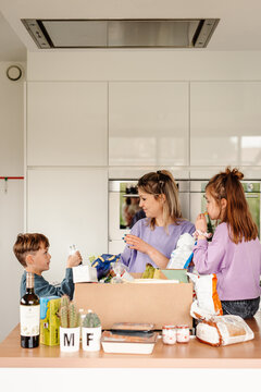 Mom and children unpack groceries