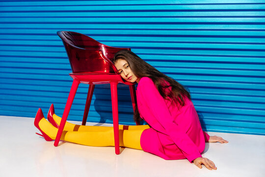 Fashionable Woman Resting Head on Red Chair