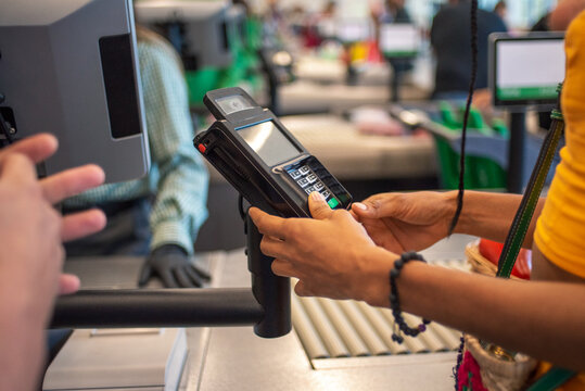 Anonymous woman paying at supermarket cashier