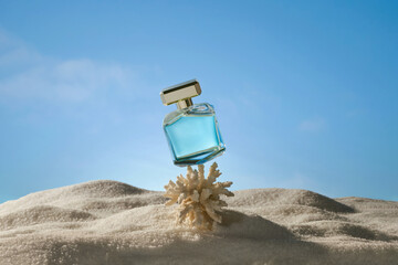 A luxurious glass perfume bottle with a golden cap on sand