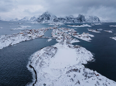 Aerial view of snowy coastal village in winter fjord