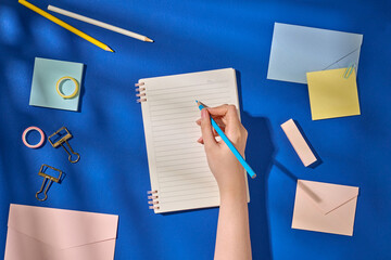 Flat Lay of Stationery Supplies and Notebook on a Blue Background