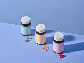 Three vitamin bottles with colorful labels are arranged on blue