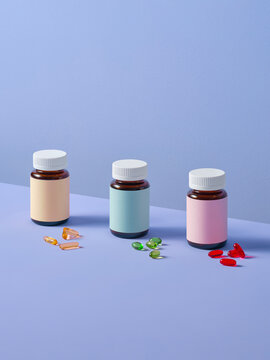 Assorted Vitamin Bottles and Capsules on Pastel Background