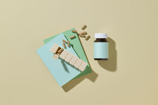 Weekly Pill Organizer and Medicine Bottle on Pastel Background