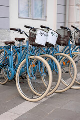 Row of turquoise rental bikes parked on sidewalk, Piran, Slovenia