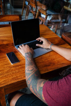 Overhead View of Tattooed Man Typing on Laptop