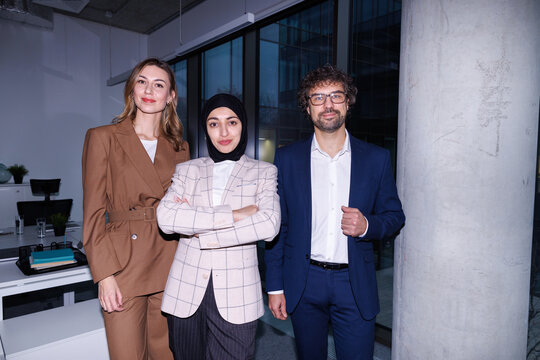Group of smiling managers posing for photo at office after work 