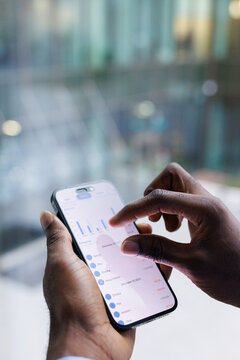 Cropped photo of anonymous black man checking data on smartphone
