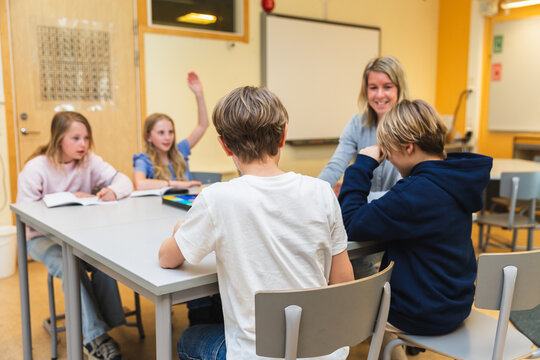Teacher Assisting Students in Classroom