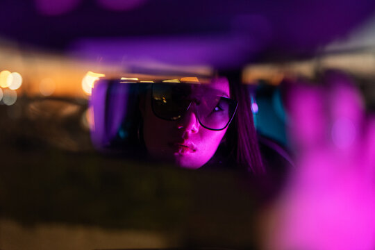Woman looking at car mirror