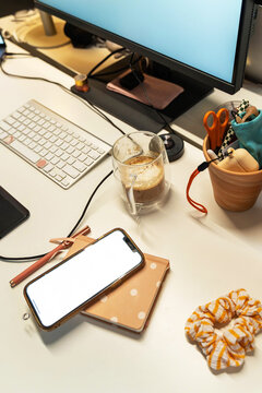 Blank screen workspace with smartphone and accessories

