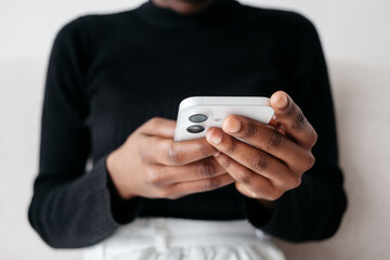 Person engaging with smartphone while sitting indoors