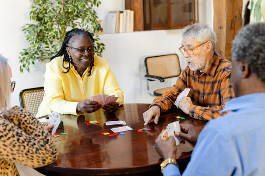 Senior woman playing cards win friends at retirement community center