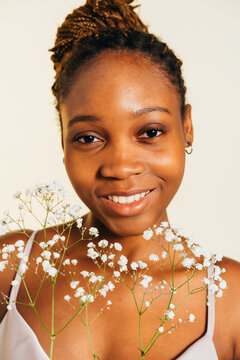 Smiling Young Woman Holding Baby's Breath Flowers in Soft Light