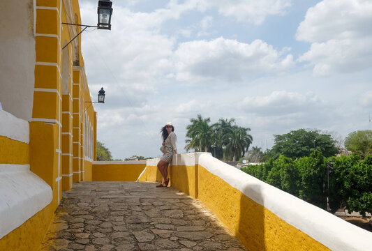Woman Walking Along Convent Wall in Izamal