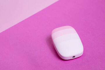 Minimalist pink silicone facial cleansing device on vibrant pastel background, modern skincare and beauty technology tool for gentle hygiene and self-care routine