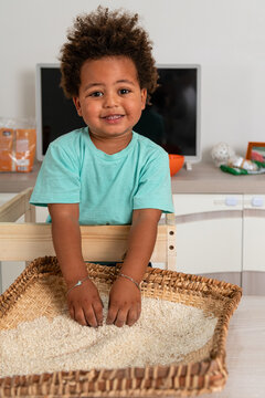 Curious african child playing with rice in a tipical congolese basket