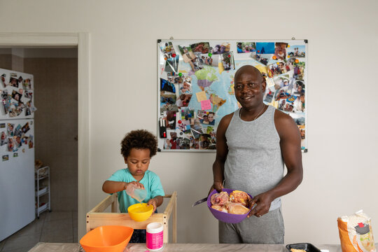 Smiling congolese father cooking with his son