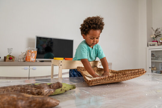 Curious african child playing with rice in a tipical congolese basket