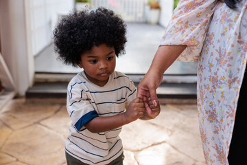 Young boy holding hands with adult in a quiet moment
