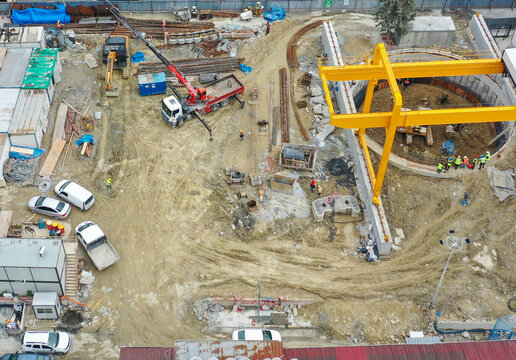 Aerial View of Construction Site with Cranes and Workers in Progress