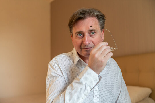 Positive businessman taking off his glasses