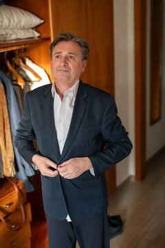 Businessman buttoning a button of his jacket in hotel room