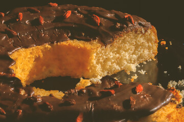 Traditional Polish bundt-style cake with rich chocolate glaze and goji berries, served on elegant glass stand, festive homemade dessert for Easter or special occasions
