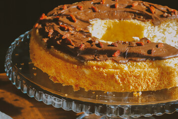 Traditional Polish bundt-style cake with rich chocolate glaze and goji berries, served on elegant glass stand, festive homemade dessert for Easter or special occasions