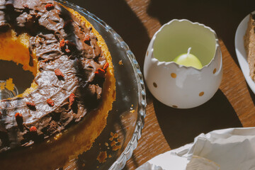 Traditional Polish bundt-style cake with rich chocolate glaze and goji berries, served on elegant glass stand, festive homemade dessert for Easter or special occasions