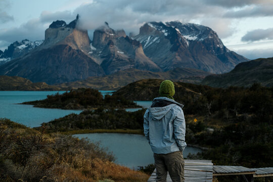 male traveler walking on a wooden path in Torres del Paine