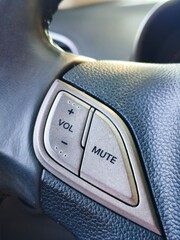 Close-Up of Car Steering Wheel Controls with Volume and Mute Buttons for Audio System or Hands-Free Use