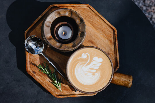 Latte Art Coffee with Candle and Spoon on Wooden Tray