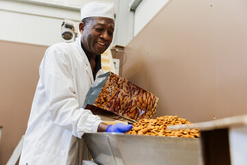 Smiling warehouse worker packaging almonds at work