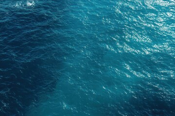 Deep blue ocean water surface with sunlight reflections and gentle waves creating a peaceful and expansive seascape