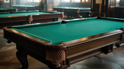 A green pool table sits in a room with other pool tables. The room is dimly lit, giving it a cozy atmosphere