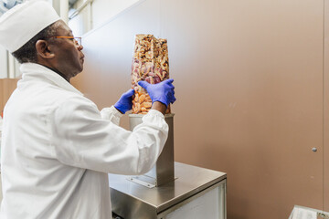 Warehouse worker vacuum sealing almond package with machine