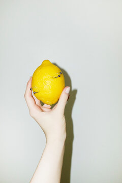 Silver metal pierced fruit citrus lemons on colourful background