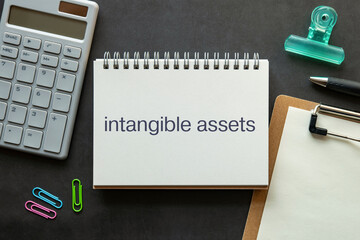 There is notebook with the word intangible assets. It is as an eye-catching image.