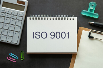 There is notebook with the word ISO 9001. It is as an eye-catching image.