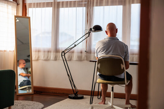 Man sitting alone at desk in a quiet, minimalist room