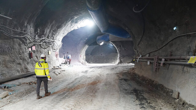 Fototapeta Industrial Underground Tunnel with Workers and Construction Machinery