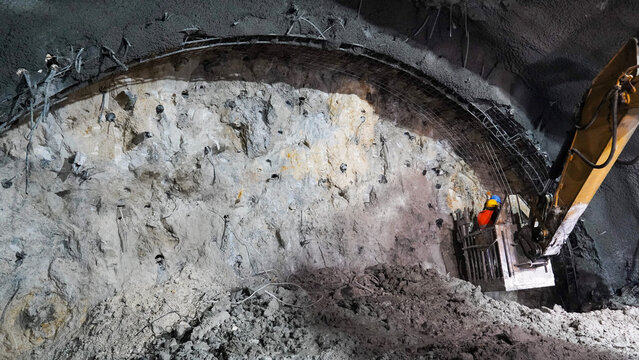 Worker Operating Heavy Machinery at Tunnel Excavation Site