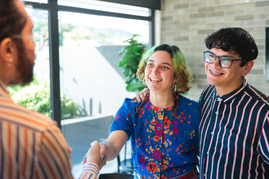 Young people shaking hands in office
