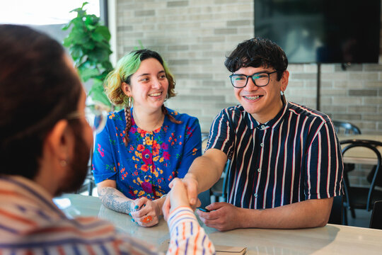 Young colleagues shaking hands at office