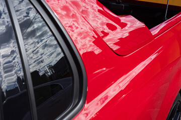 Close-Up of a Red Car Reflecting City Elements