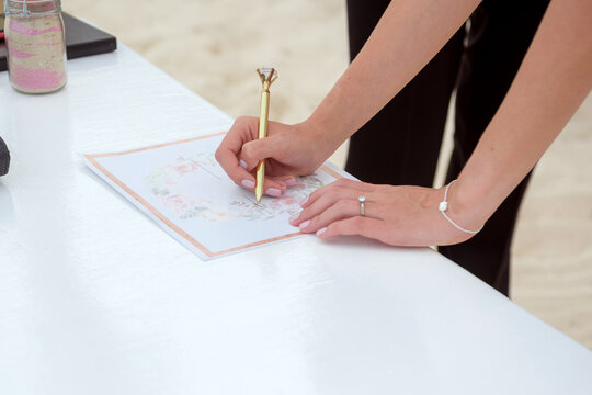 The bride signs the certificate of marriage. Mexico.