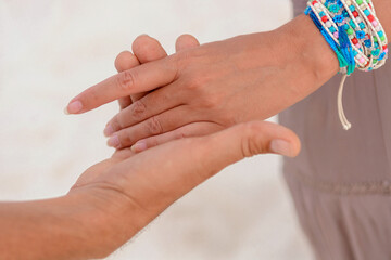 Man and woman, newlyweds holding hands with blurred background.